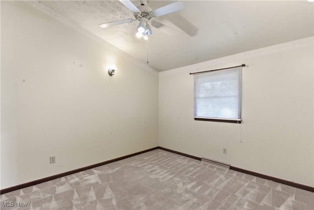 54846 Seneca Lake Road Quaker City, OH 43773 - Photo 23 of 42 Carpeted empty room with crown molding and a ceiling fan