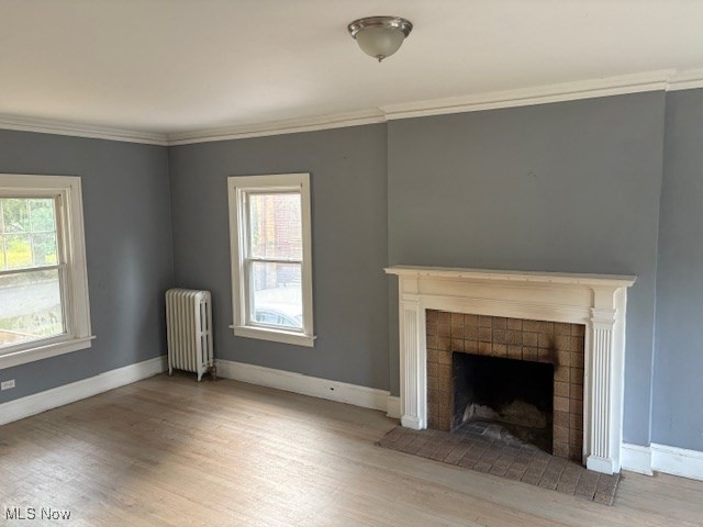 3258 Berkshire Road Cleveland, OH 44118 - Photo 6 of 23 Unfurnished living room with wood finished floors, radiator heating unit, a fireplace, and crown molding