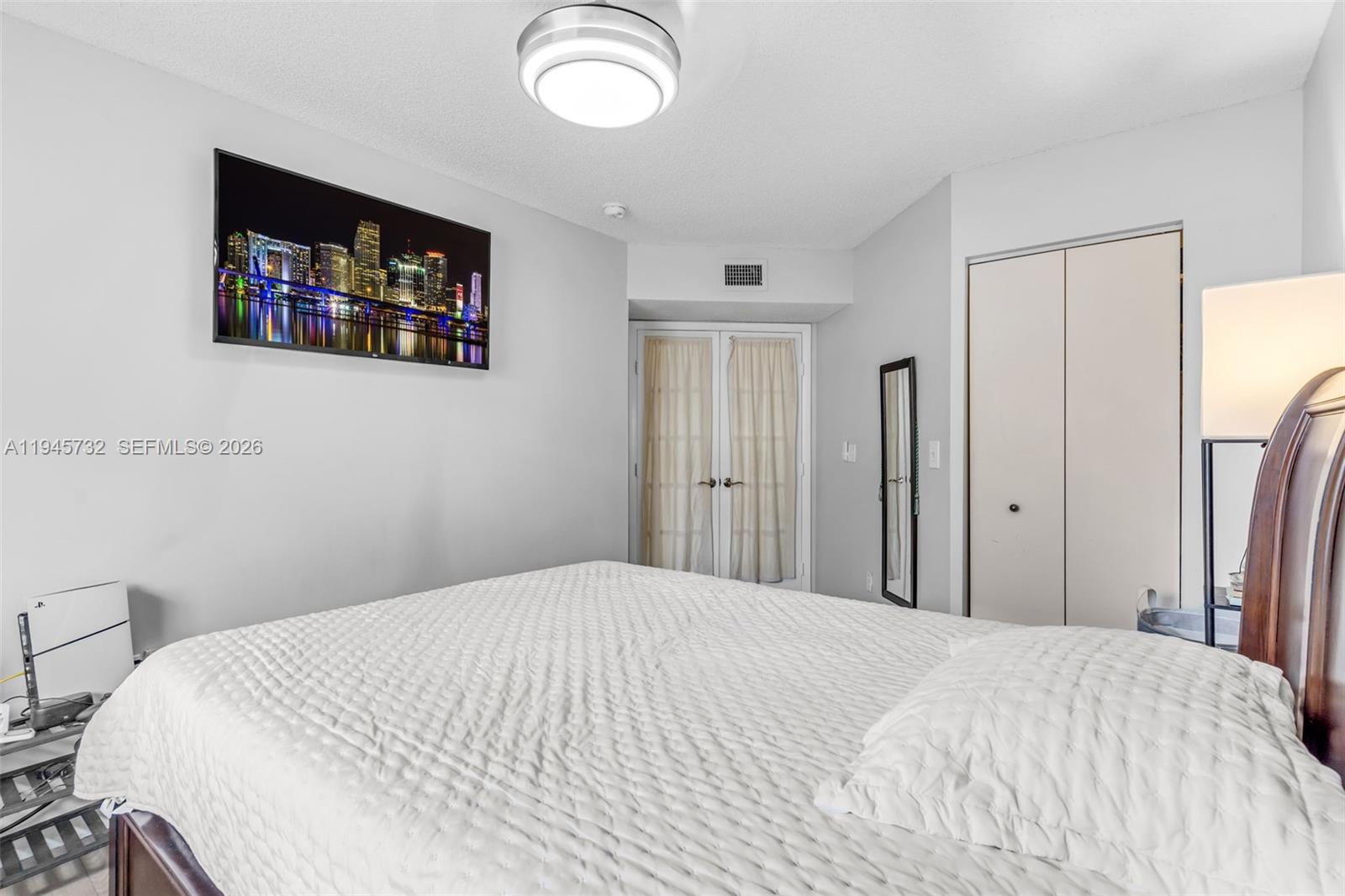 2520 Southeast 20th Place, Unit 204B Homestead, FL 33035 - Photo 17 of 45 a bedroom with a bed and a painting on the wall