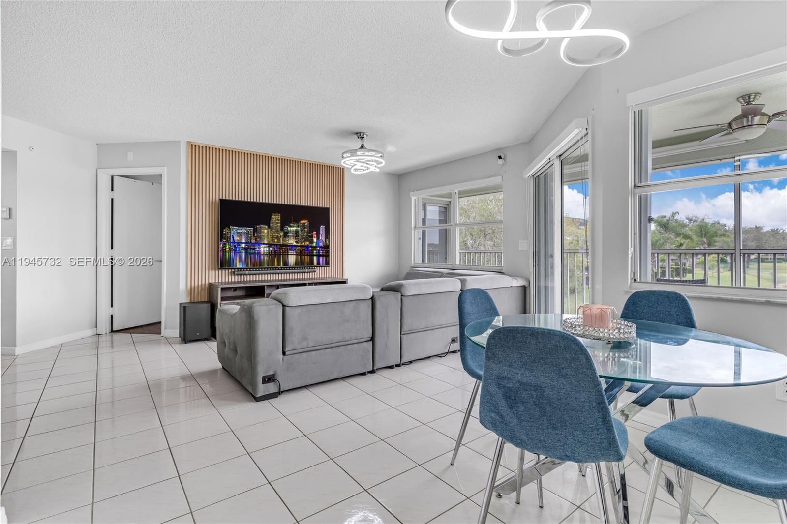 2520 Southeast 20th Place, Unit 204B Homestead, FL 33035 - Photo 5 of 45 a living room with furniture a flat screen tv and a large window