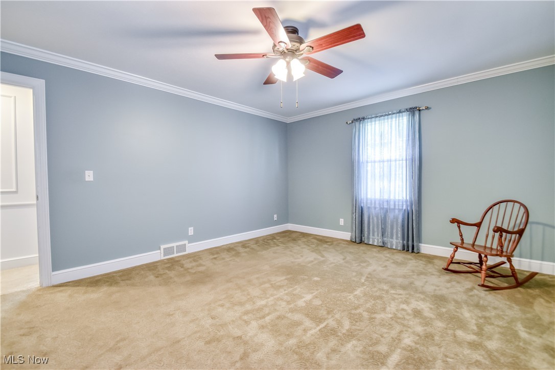 9715 Johnnycake Ridge Road Mentor, OH 44060 - Photo 10 of 50 Carpeted empty room featuring crown molding and a ceiling fan