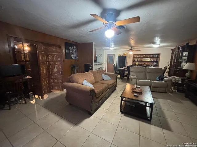 a living room with furniture a lamp and a ceiling fan