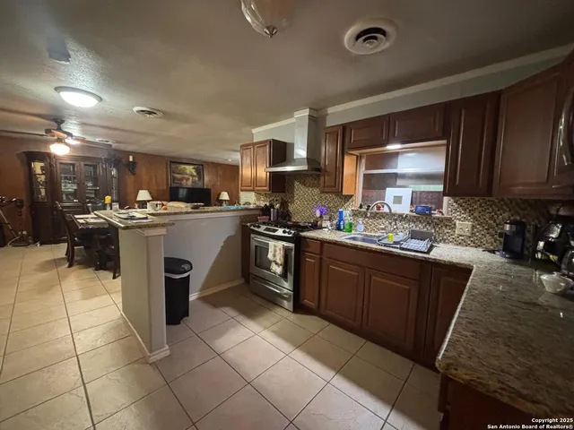 a kitchen with a sink a stove top oven and cabinets