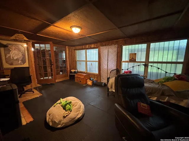 a living room with furniture a large window with kitchen view