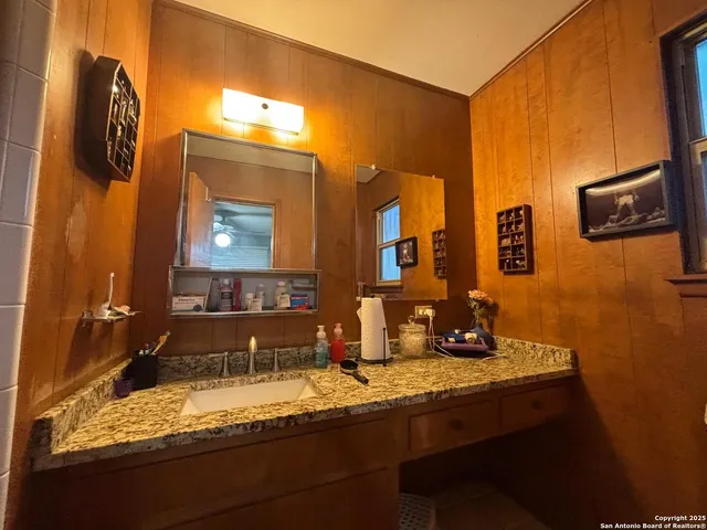 a bathroom with a granite countertop sink and a mirror