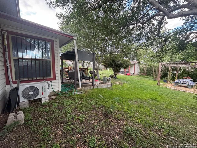 a view of a backyard with table and chairs and a large tree