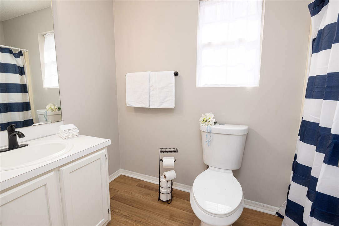 410 South Cove Road Seneca, SC 29672 - Photo 18 of 25 This bright bathroom features warm wood-look flooring and a functional vanity with ample counter space.