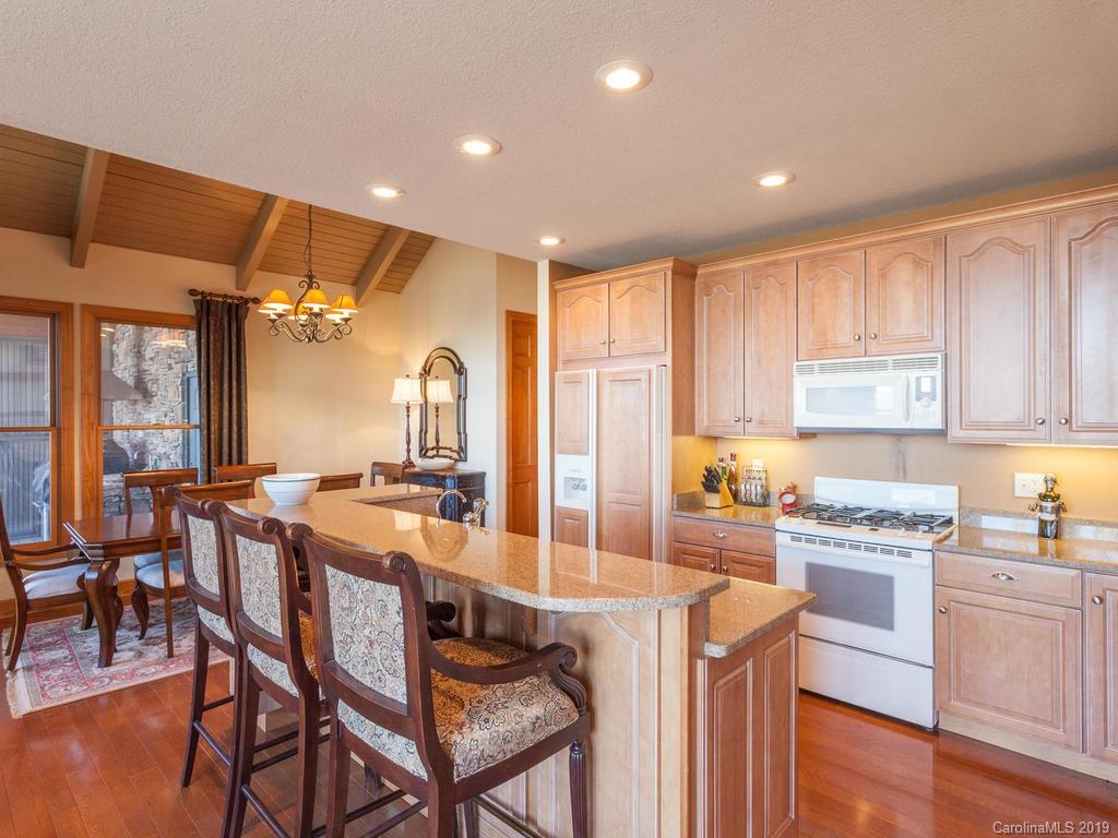 755 Andrew Banks Road Burnsville, NC 28714 - Photo 5 of 24 a kitchen with stainless steel appliances granite countertop a stove top oven a sink dishwasher and white cabinets with wooden floor