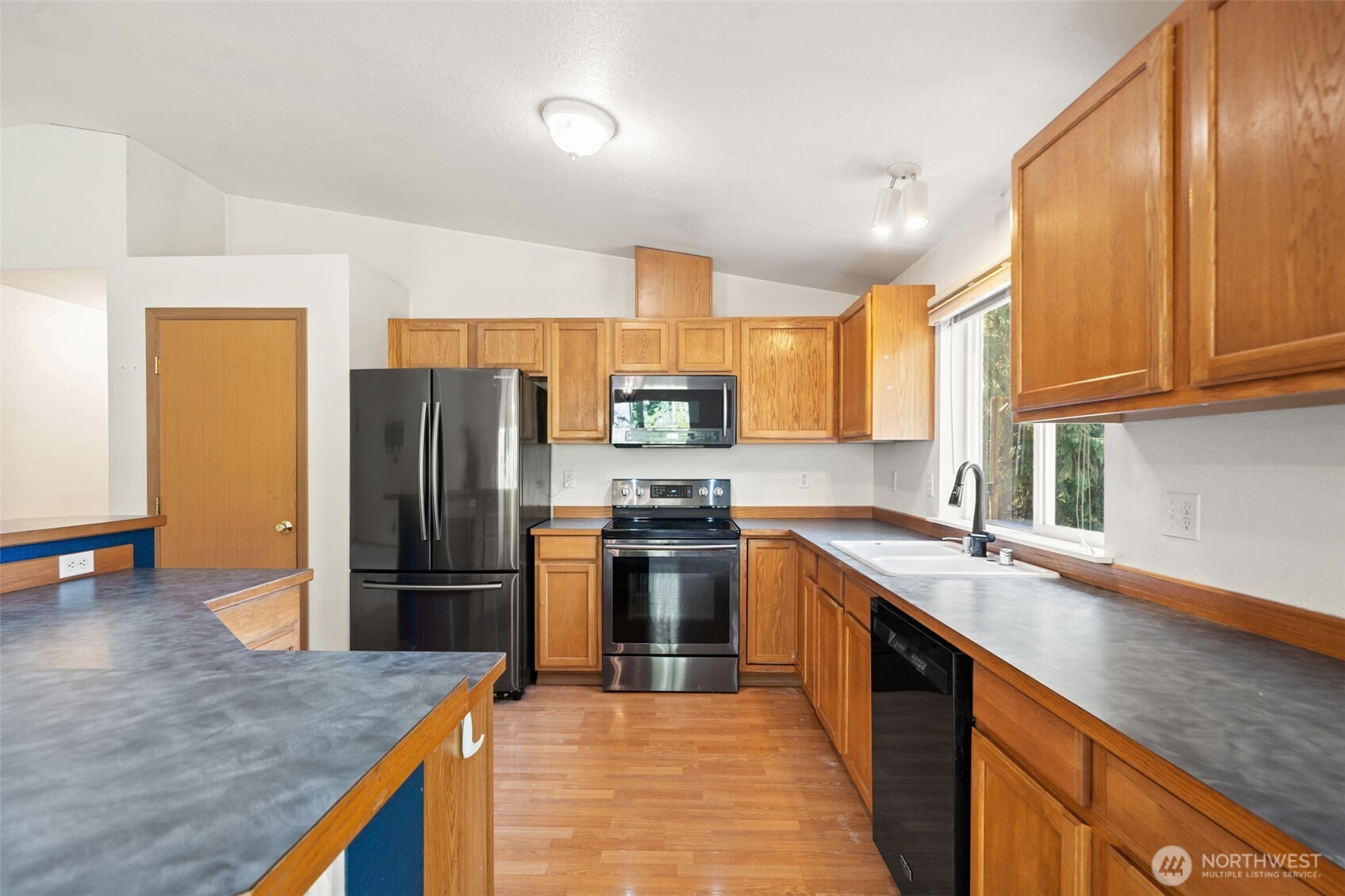 297 Lewis Road West Seabeck, WA 98380 - Photo 14 of 35 a kitchen with stainless steel appliances granite countertop a refrigerator a sink a stove a microwave and island