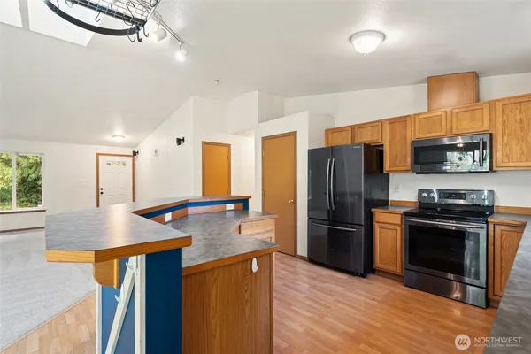 a kitchen with stainless steel appliances granite countertop a refrigerator a stove and a sink