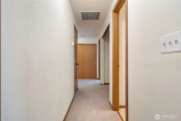 a view of a hallway with wooden floor