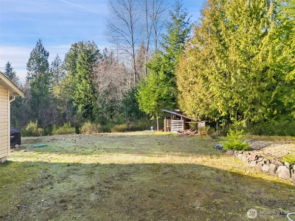 a backyard of a house with potted plants and large tree