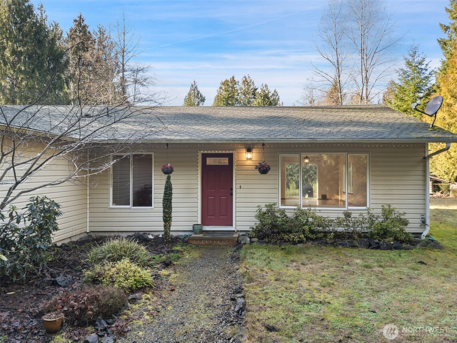 297 Lewis Road West Seabeck, WA 98380 - Photo 3 of 35 a view of a house with potted plants and a large tree