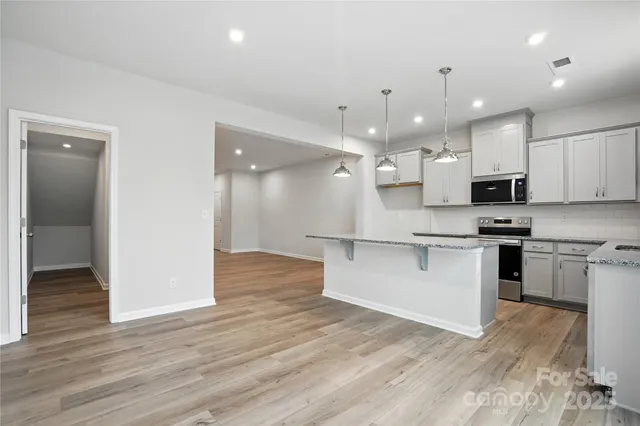 a large kitchen with kitchen island a sink stainless steel appliances and cabinets