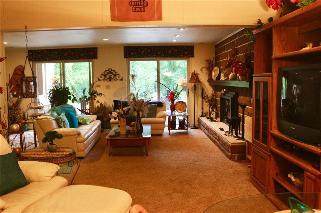 241 McKinney Road Wexford, PA 15090 - Photo 20 of 25 Large Game Room with 2 sets of sliders, brown stone fireplace taken from a North Side Mansion, gas fireplace ,neutral dcor, distressed wood mantle. Great Party Room.