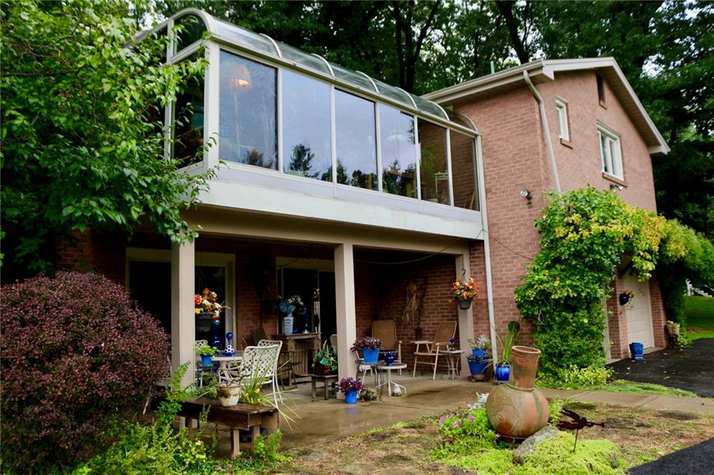 241 McKinney Road Wexford, PA 15090 - Photo 23 of 25 Rear view of the home, partially covered patio, trellis over the garage door, parking for 8 to 10 vehicles. The property back into North Park so no building behind this property. Tranquil feeling. Sit on the patio & enjoy nature.