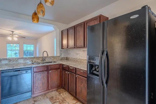 a kitchen with stainless steel appliances granite countertop a refrigerator and a sink