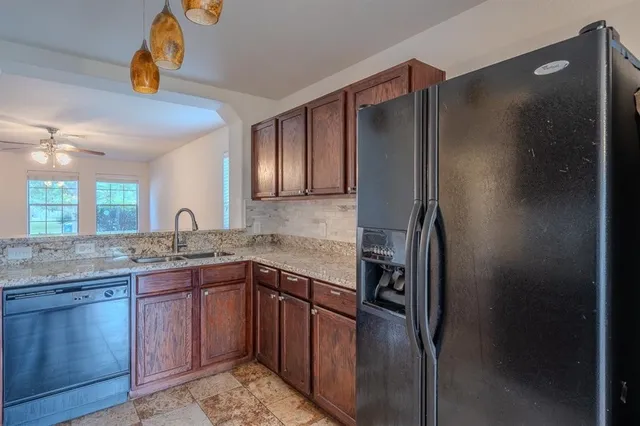 a kitchen with stainless steel appliances granite countertop a refrigerator and a sink