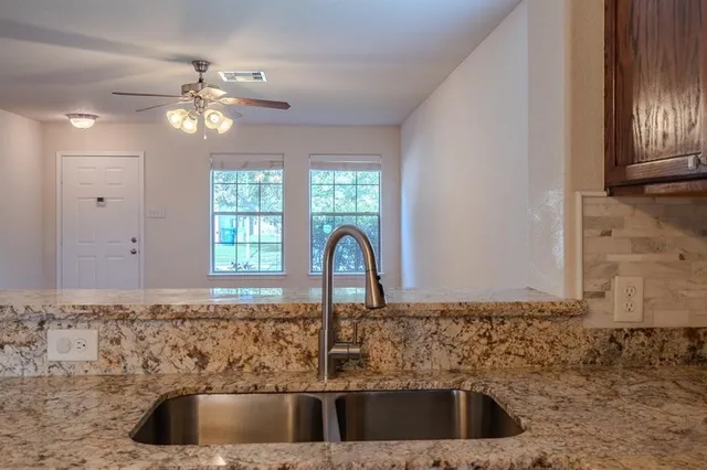 a kitchen with sink a faucet and chandelier