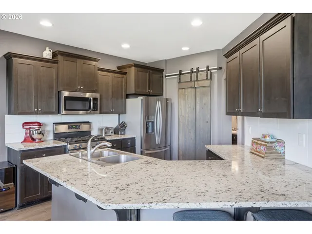 a kitchen with stainless steel appliances granite countertop a sink refrigerator and microwave
