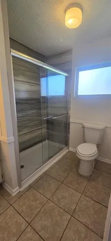 a bathroom with a toilet and a shower