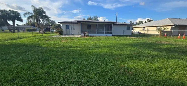 a front view of a house with a yard and table and chairs under an umbrella