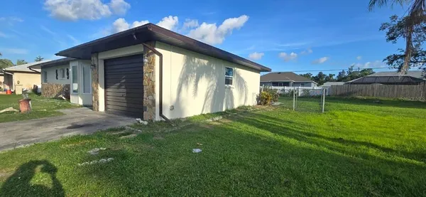 a backyard of a house with table and chairs
