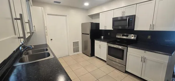 a kitchen with a refrigerator stove and microwave