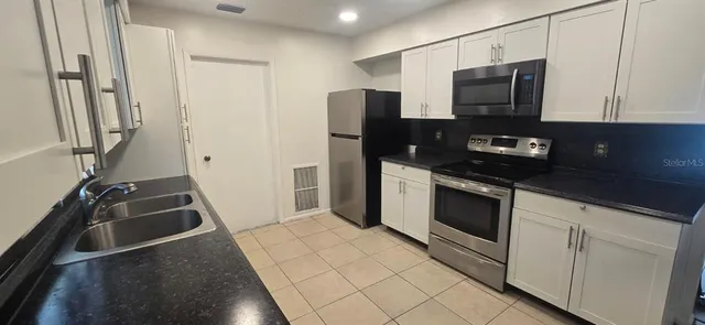 a kitchen with a refrigerator stove and microwave