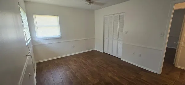 an empty room with wooden floor and a window