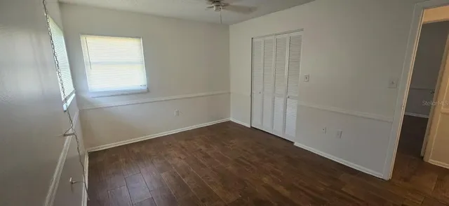 an empty room with wooden floor and a window