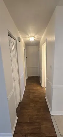 a view of a hallway with wooden floor