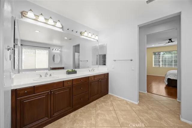 a spacious bathroom with a double vanity sink a mirror and a shower