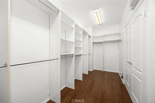 a view of a hallway with wooden floor and closet