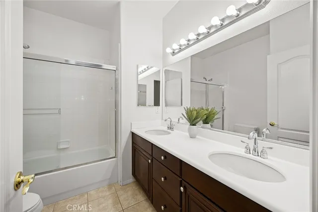 a bathroom with a bathtub double vanity sink and mirror
