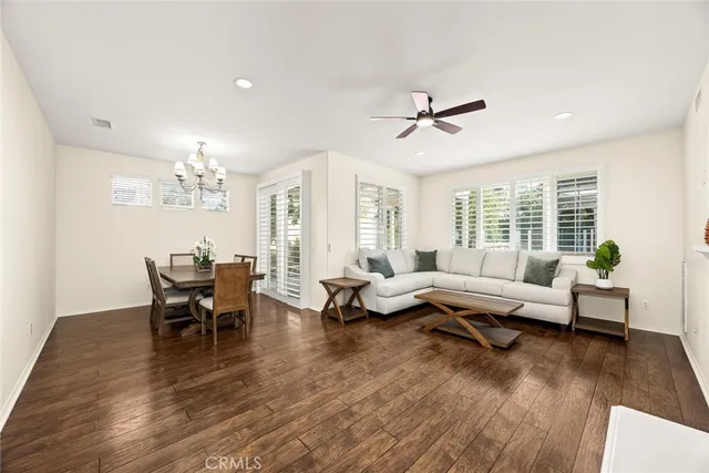 a living room with furniture dining table and a chandelier