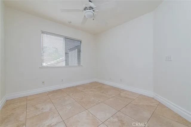 a view of an empty room with a fireplace and a window