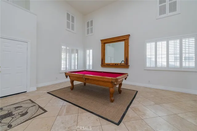 a room with pool table and windows