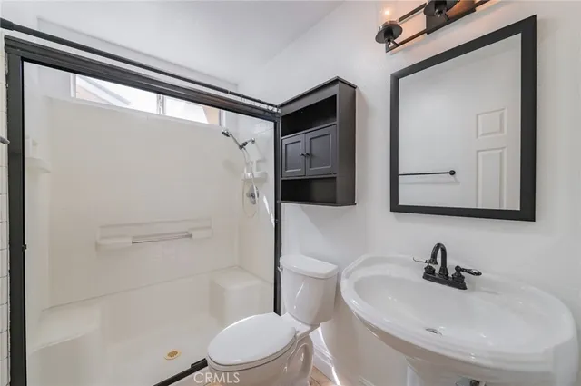 an empty room with a chandelier fan and windows