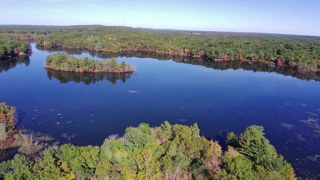 an aerial view of a house with lots of green space and a lake view