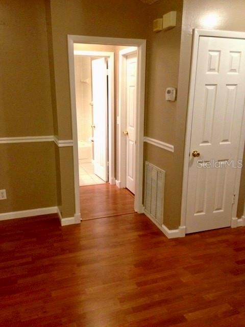 8330 Duval Drive Port Richey, FL 34668 - Photo 14 of 20 an empty room with wooden floor and windows