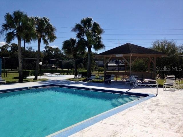 8330 Duval Drive Port Richey, FL 34668 - Photo 18 of 20 a view of swimming pool with outdoor seating and a garden