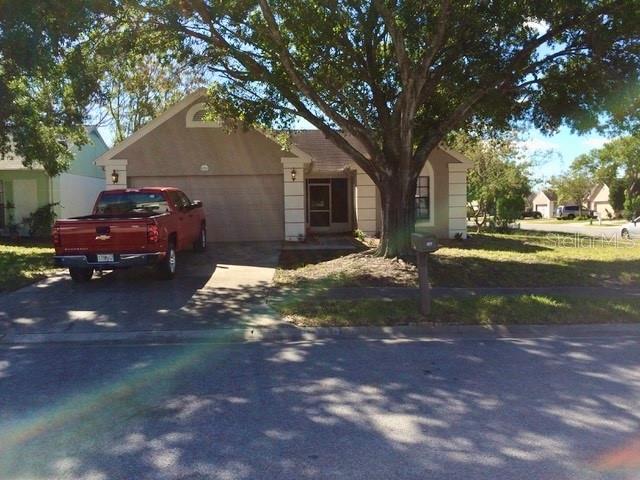 8330 Duval Drive Port Richey, FL 34668 - Photo 2 of 20 a front view of a house with a yard and garage