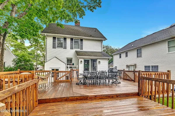 a view of a house with wooden deck and furniture