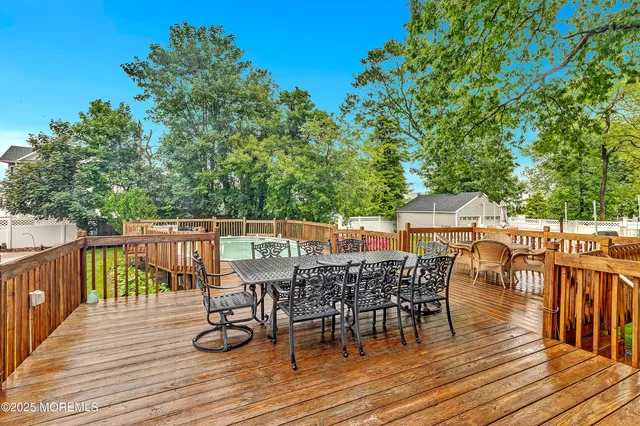a balcony with wooden floor table and chairs