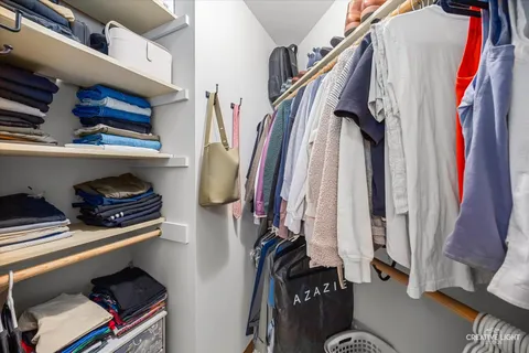 a view of walk in closet with clothes and shoes