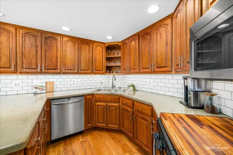 a kitchen with stainless steel appliances granite countertop wooden cabinets a sink and dishwasher