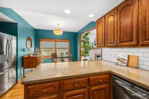 a kitchen with stainless steel appliances granite countertop a sink a stove cabinets counter space and living room view