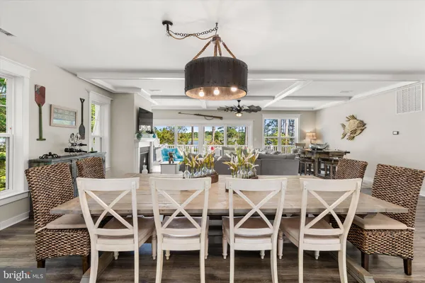 a dining room with furniture a chandelier and wooden floor