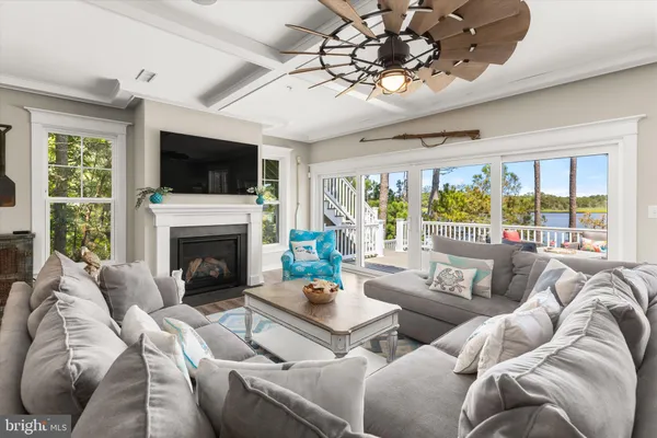 a living room with furniture a flat screen tv and a large window